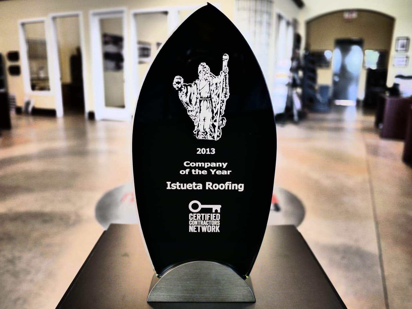 Istueta Roofing's 2013 Certified Contractors Network Company of the Year award, an engraved black glass trophy displayed in the company office