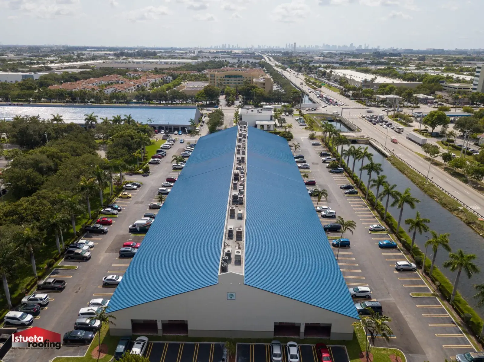 Close-up of galvalume standing-seam panel installation showing concealed-clip fastening system on a South Florida roof deck
