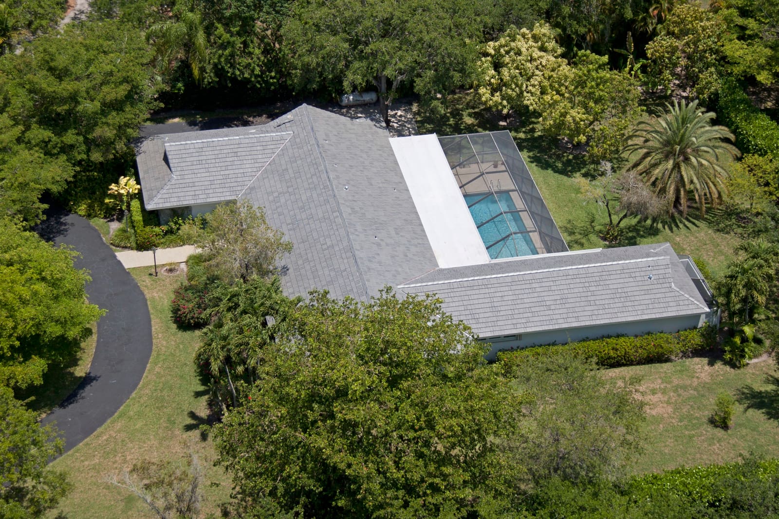 Gray Crown concrete tile roof across a low-slung Pinecrest estate, aerial view.