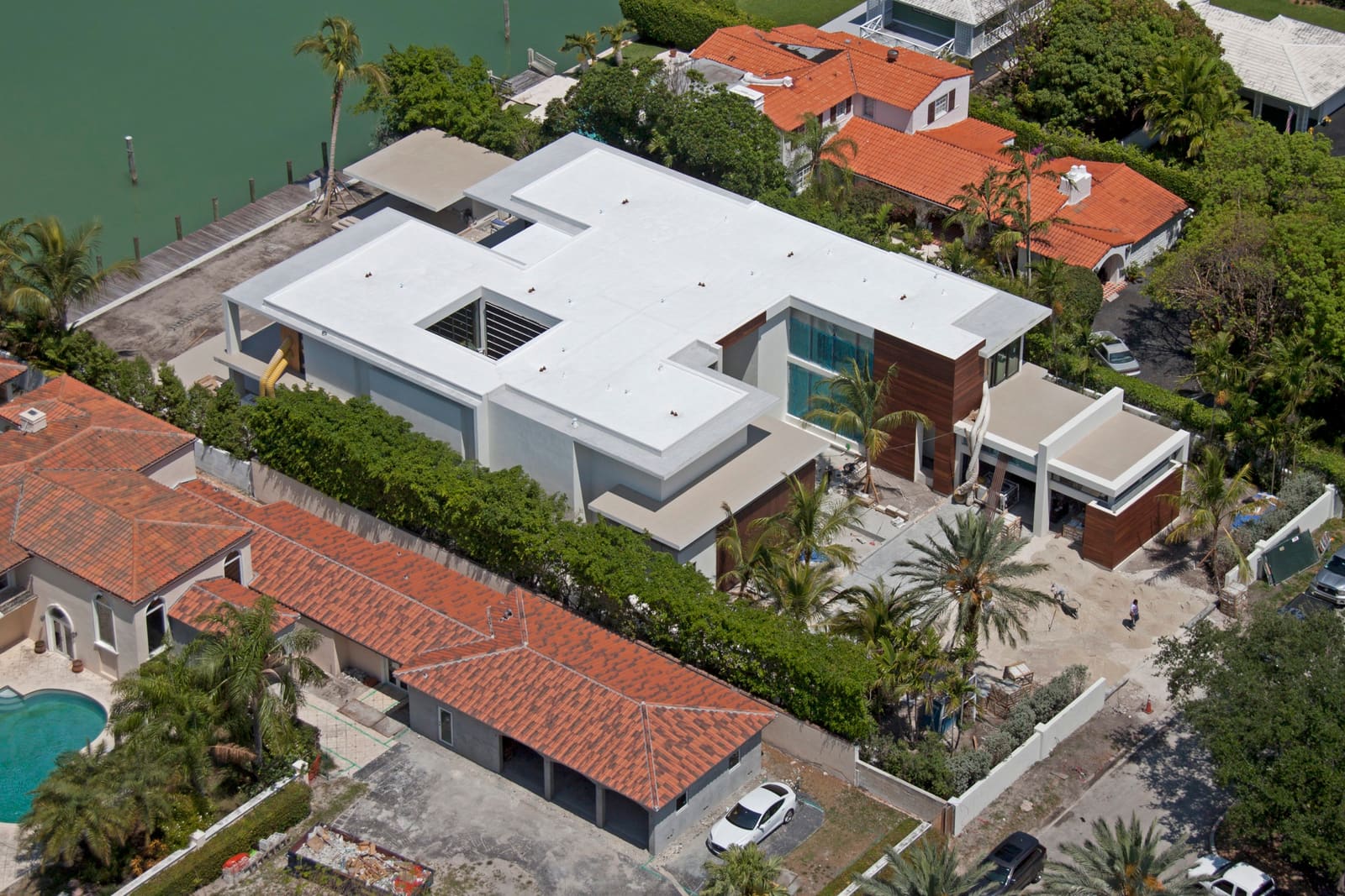 Aerial view of a contemporary bayfront home with a white TPO flat membrane roof.