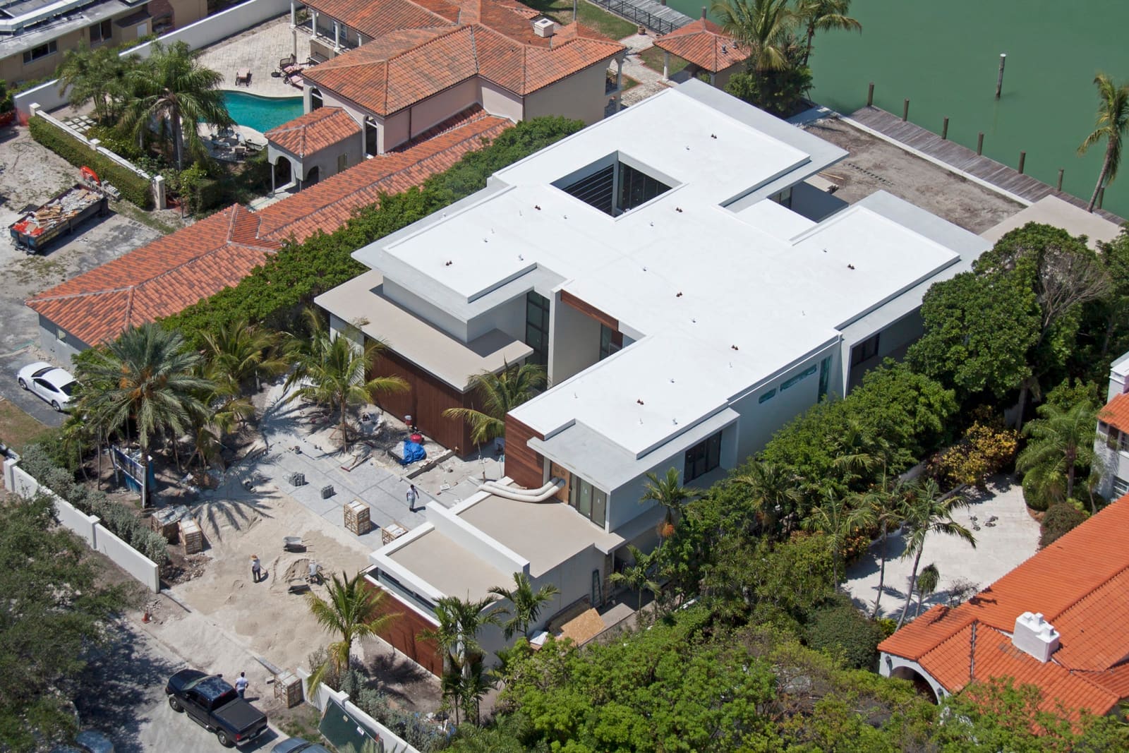 Aerial view of a modernist bayfront home with a white TPO flat membrane roof.