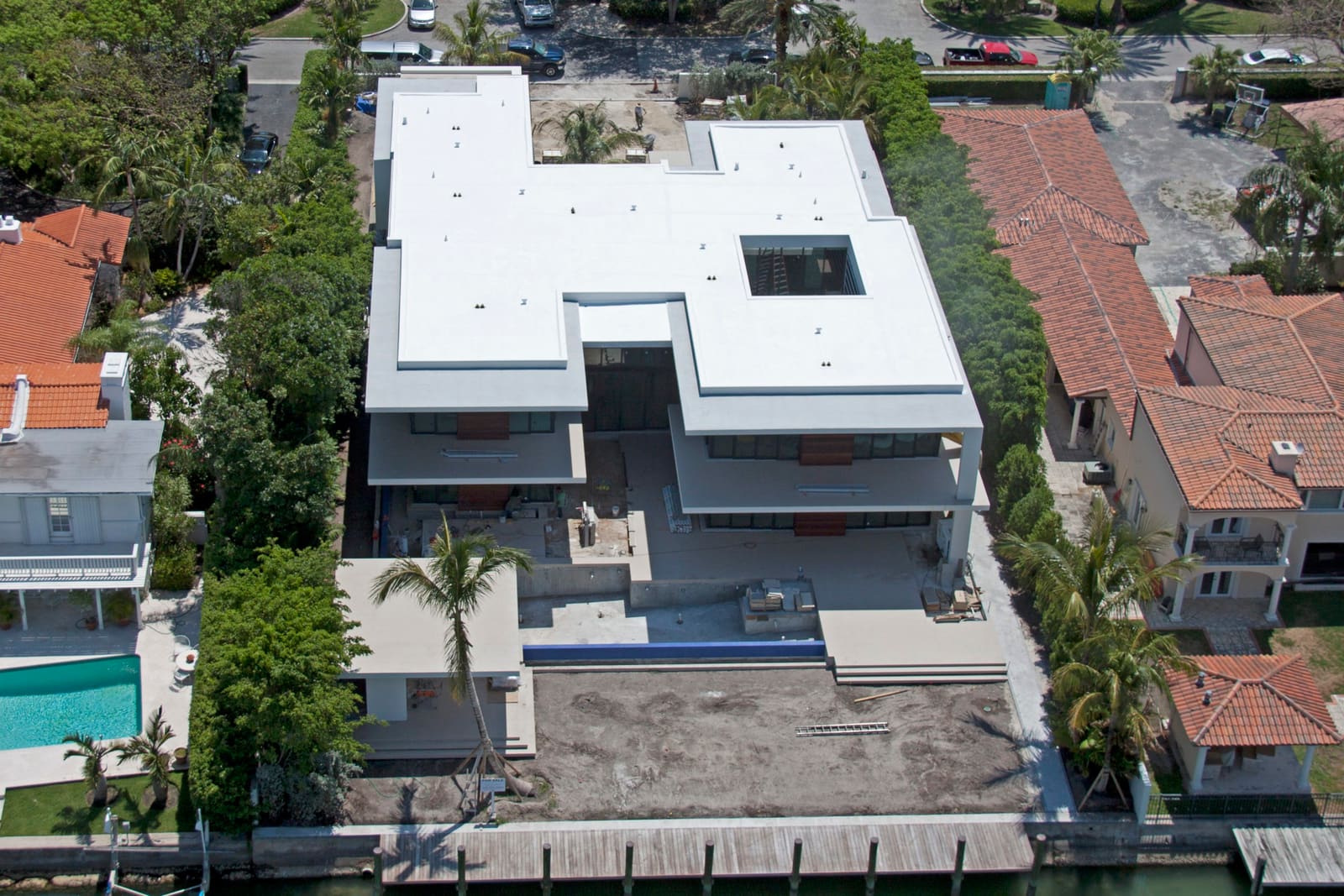 White TPO flat membrane roof on a South Florida waterfront property, aerial view.