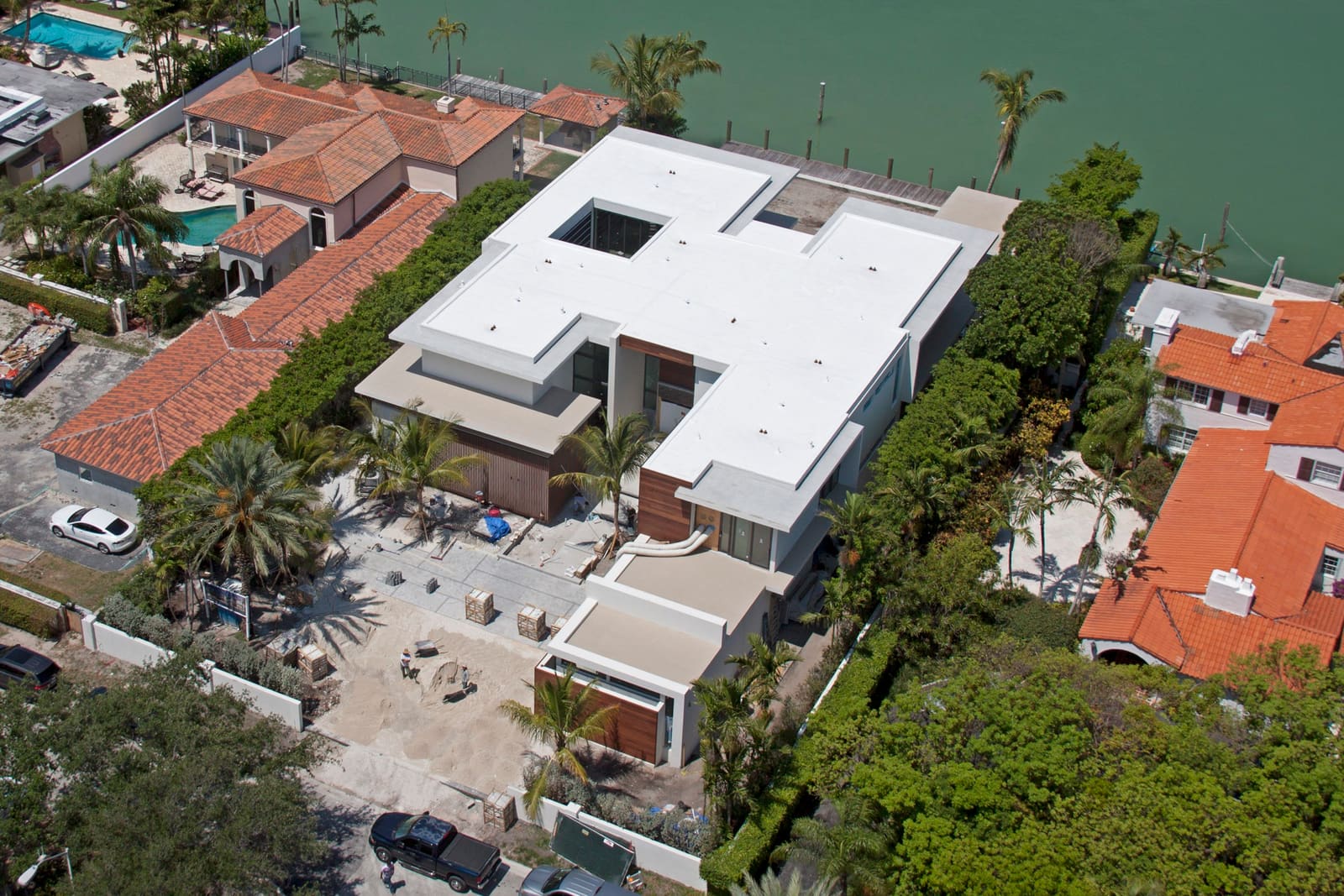 Cool-roof white flat membrane over a low-slope roof section, aerial view.