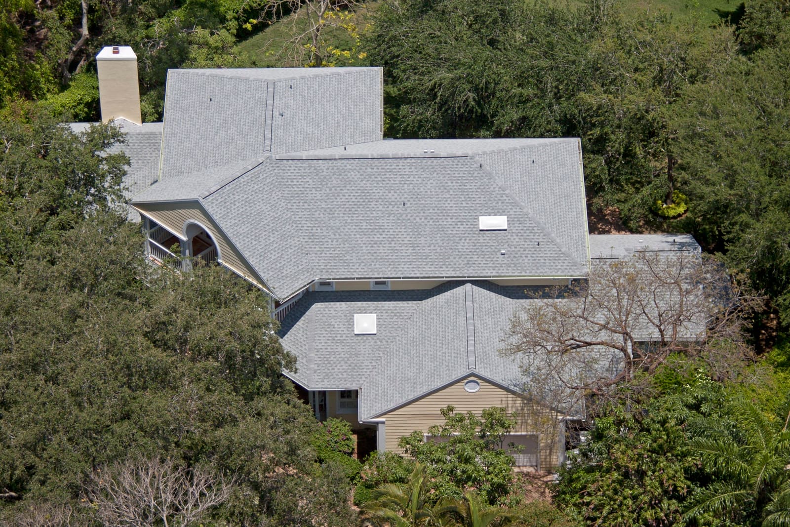 Architectural asphalt shingle across a complex hip-and-gable roof, aerial view.
