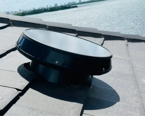 A solar attic fan installed on a tile roof in Miami.