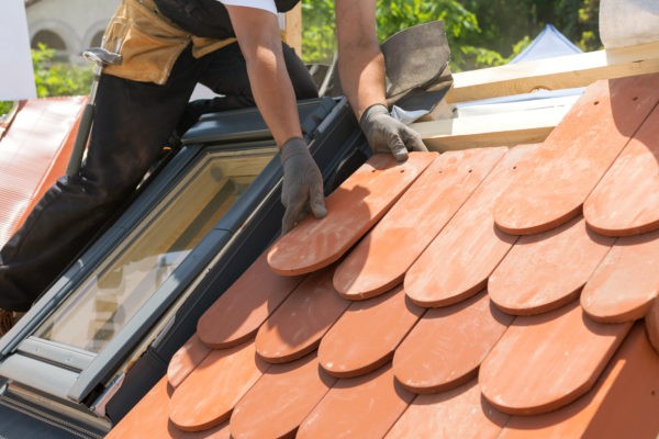 Roof technician installing special tile roof