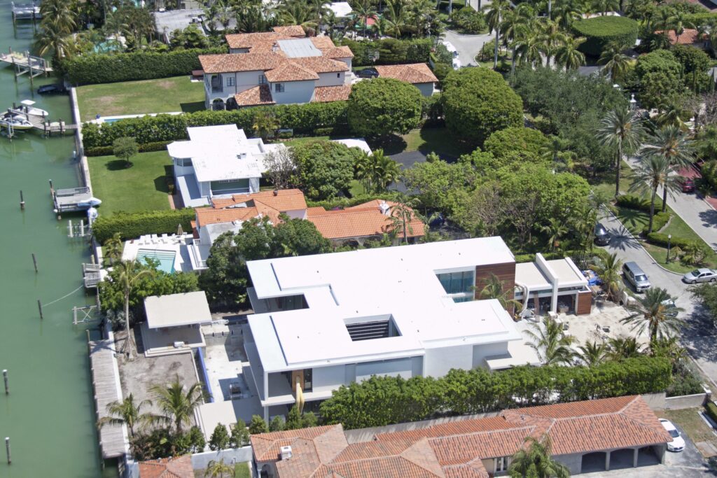 Aerial view of Miami Beach community with large building that has a white flat roof