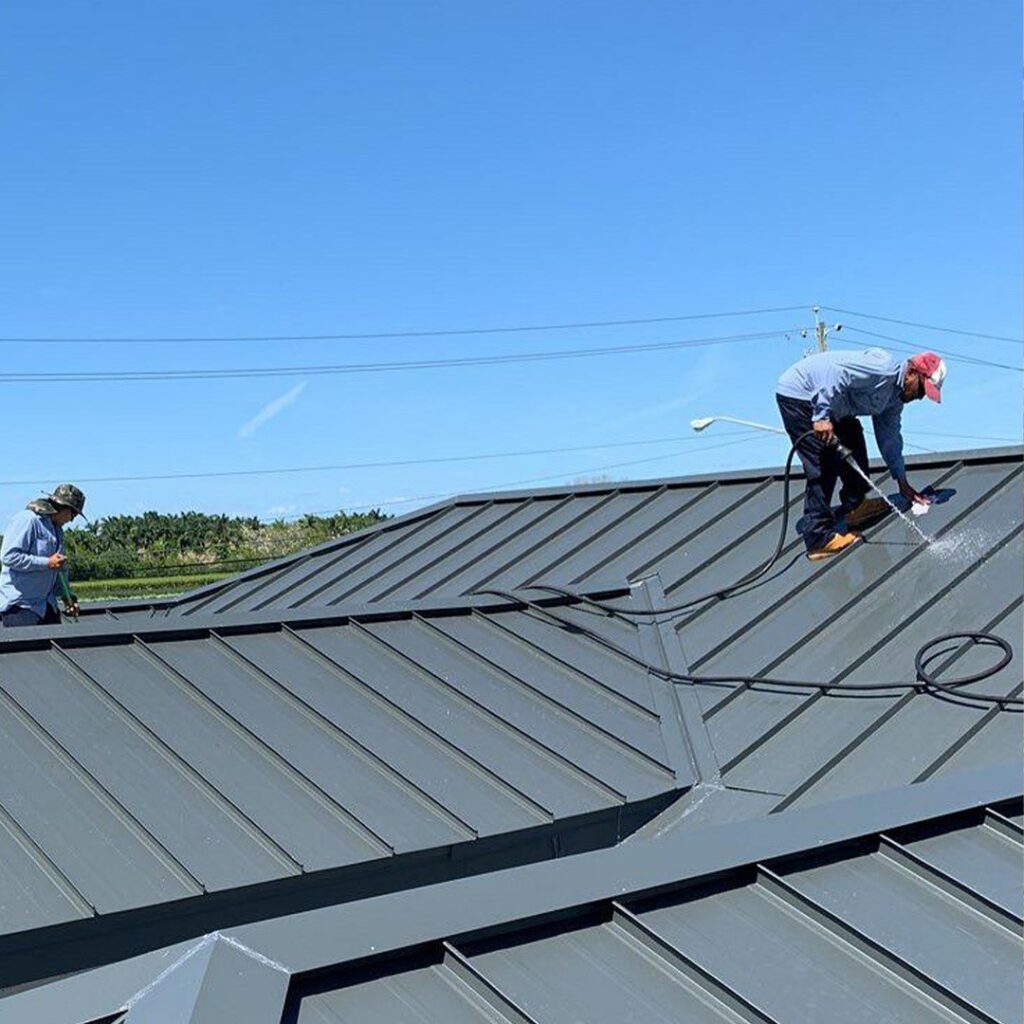 Workers cleaning shiny new aluminum roof