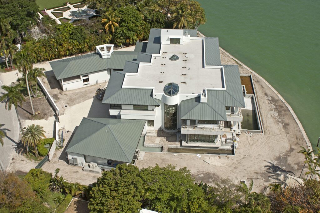 Aerial view of large building by the water with a large portion of flat roofing